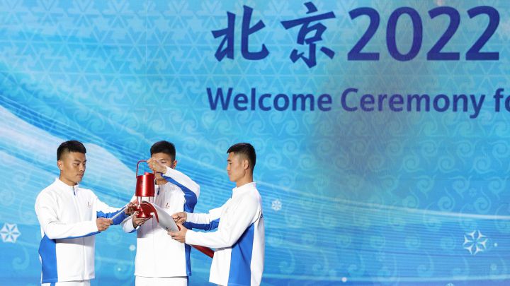 Varios relevistas portan la antorcha olímpica a su llegada a China para los Juegos Olímpicos de Invierno de Pekín 2022.