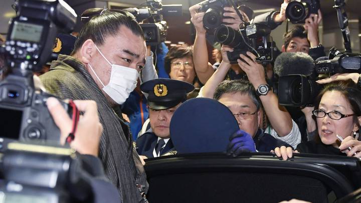 El campeón de sumo o 'yokozuna' Harumafuji es fotografiado por los medios a su llegada al aeropuerto de Haneda en Tokio, Japón, para comparecer ante la policía por la presunta agresión a otro luchador.