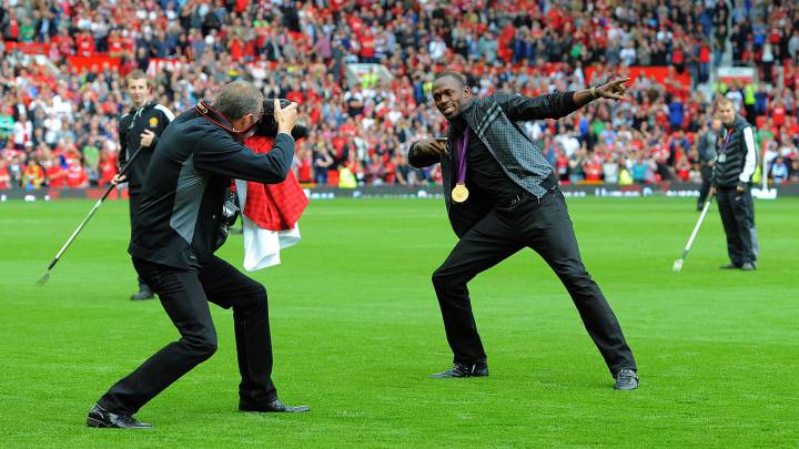 Usain Bolt hace su famoso gesto sobre el césped de Old Trafford tras ser homenajeado por la afición del Manchester United tras ganar el oro de 100 metros lisos en los Juegos Olímpicos de Londres.