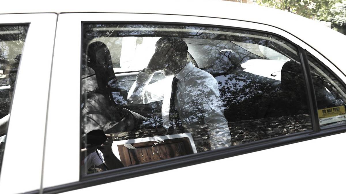Oscar Pistorius se tapa la cara a su salida de la prisión para cudir al funeral de su abuelo