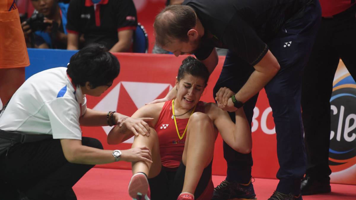 Carolina Marín es atendida tras lesionarse durante la final del Masters de Indonesia que le enfrentaba a la india Saina Nehwal.