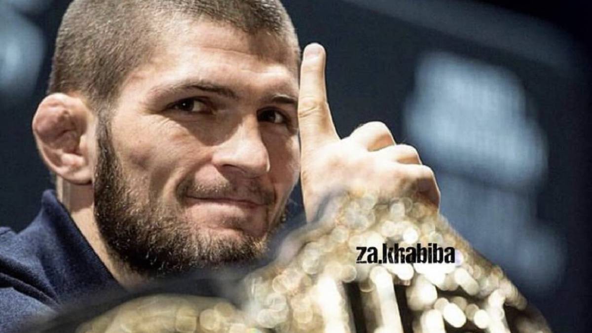 Khabib Nurmagomedov hace el gesto del número 1 junto al cinturón del peso ligero de la UFC.
