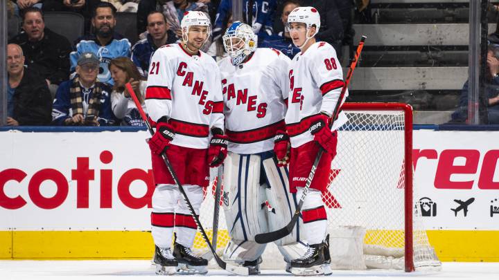 Nino Niederreiter y Martin Necas hablan con el portero Dave Ayres durante el partido entre los Carolina Hurricanes y los Toronto Maple Leafs en el Scotiabank Arena de Toronto, Ontario, Canada.