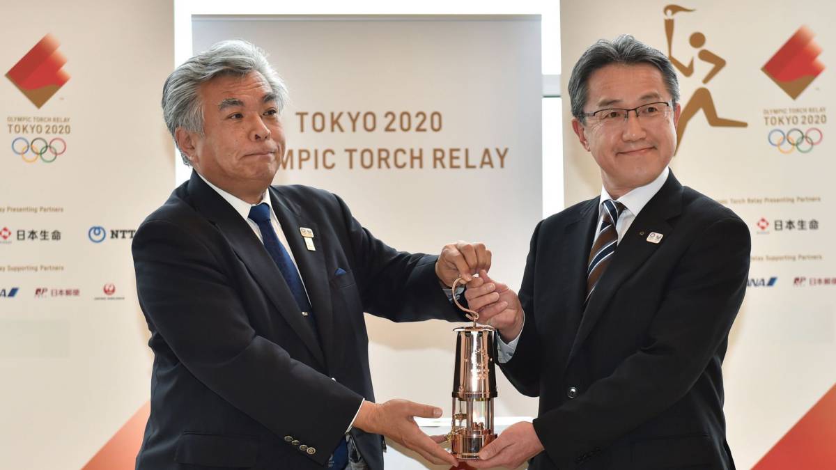 Yukihiko Nunomura y Makoto Noji posan con la llama olímpica durante el relevo de Tokio 2020 a la prefectura de Fukushima.