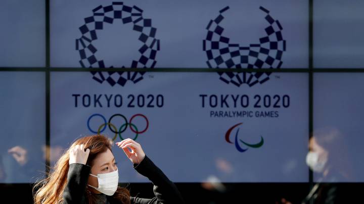 Una ciudadana pasea por delante de un escaparate con los logos de Tokio 2020.