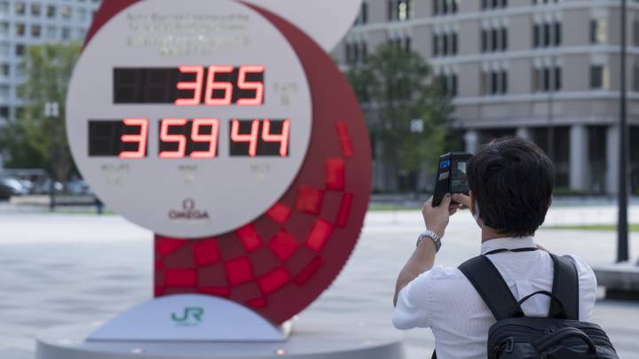 Un hombre toma una foto al reloj que marca la cuenta atrás para el inicio de los Juegos Paralímpicos de Tokio 2020.