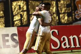 Fidel Martínez es felicitado por Ludueña tras su segunda anotación del partido.