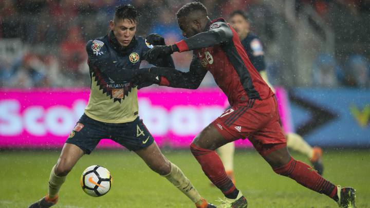 Edson Álvarez disputa el balón con Jozy Altidore.
