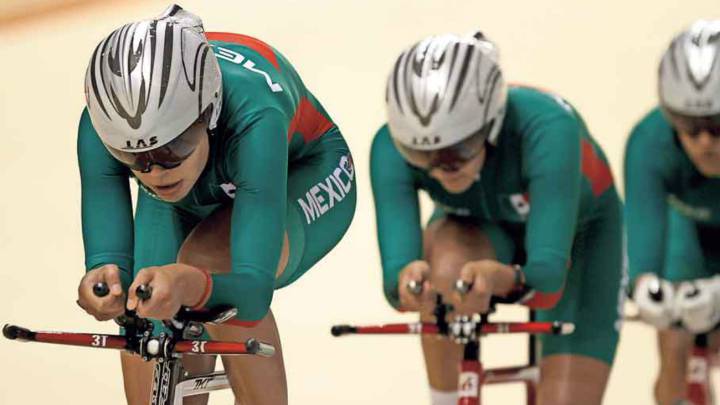 Ciclistas mujeres vestidas de verde arriba de su bicicleta