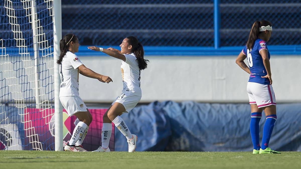 Jugadoras de fútbol festejando un gol y a punto de abrazarse