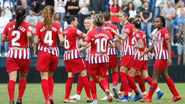 Jugadoras de Fútbol celebrando un gol, viesten short rojo y playera roja con rayas blancas