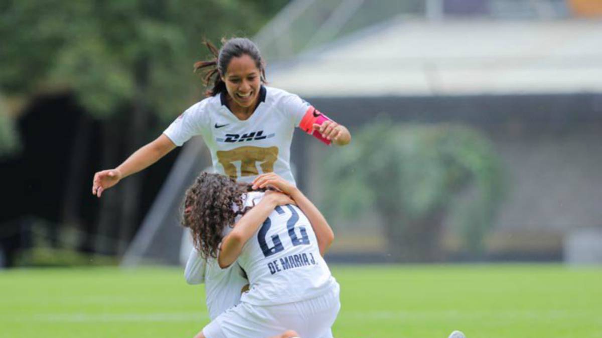 Jugadoras tiradas en el campo de juego festejando el gol