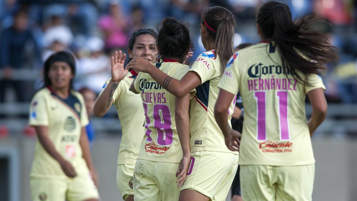 Jugadoras de fútbol vestidas de amarillo festejando una anotación