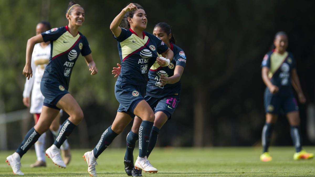 Jugadoras de fútbol corriendo por el campo de juego