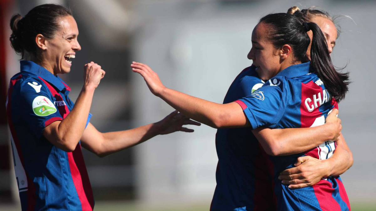 Jugadoras de fútbol festejando una anotación abrazandoce