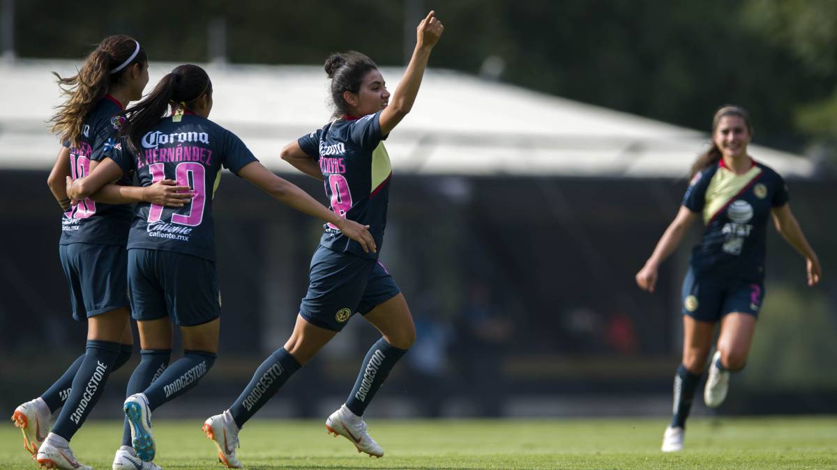 Jugadoras de fútbol corriendo por el campo de juego