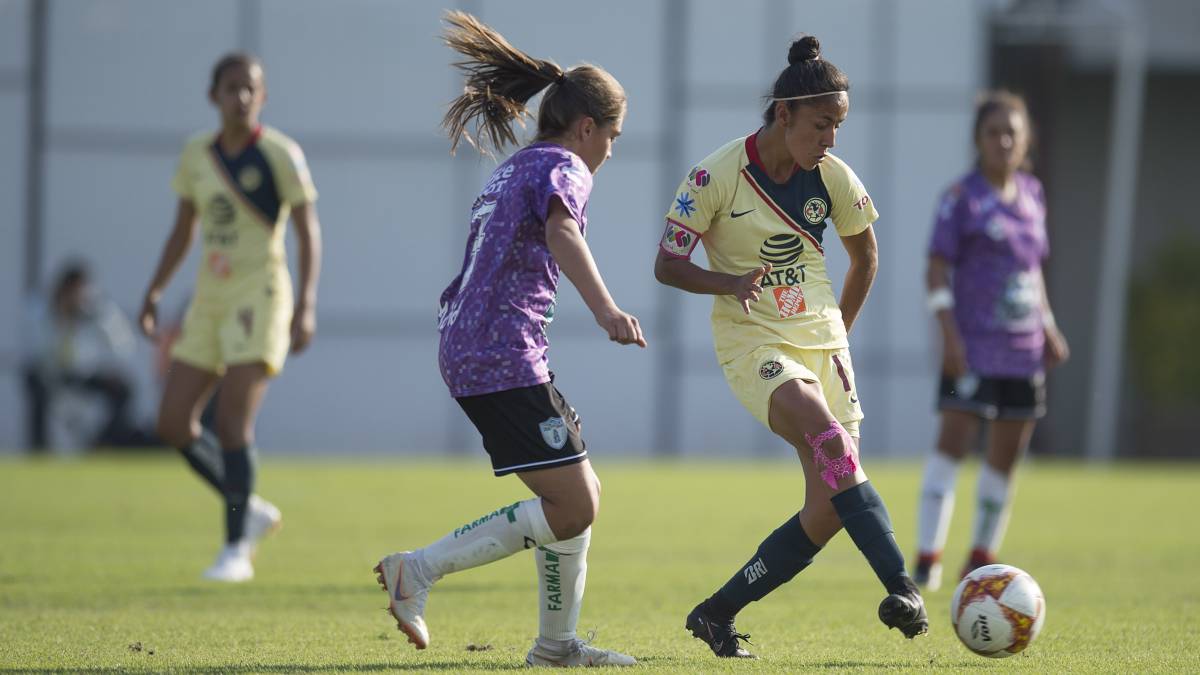 Jugadoras de fútbol corriendo por el campo de juego