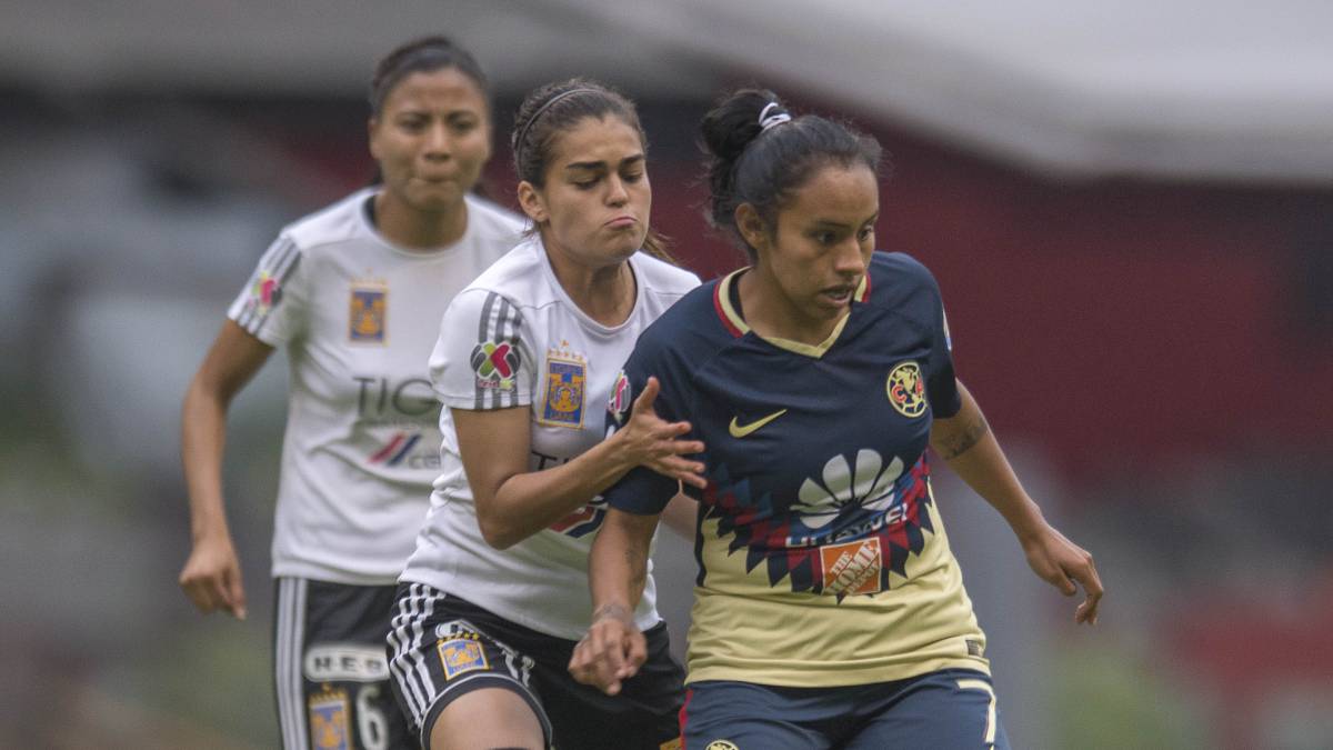 Jugadoras de fútbol disputando el balón en el campo de juego