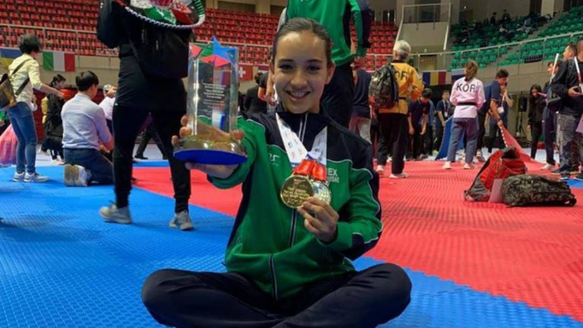 Mujer deportista sosteniendo una medalla y un trofeo