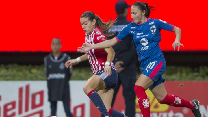 Jugadoras de fútbol disputando el balón en la cancha de juego