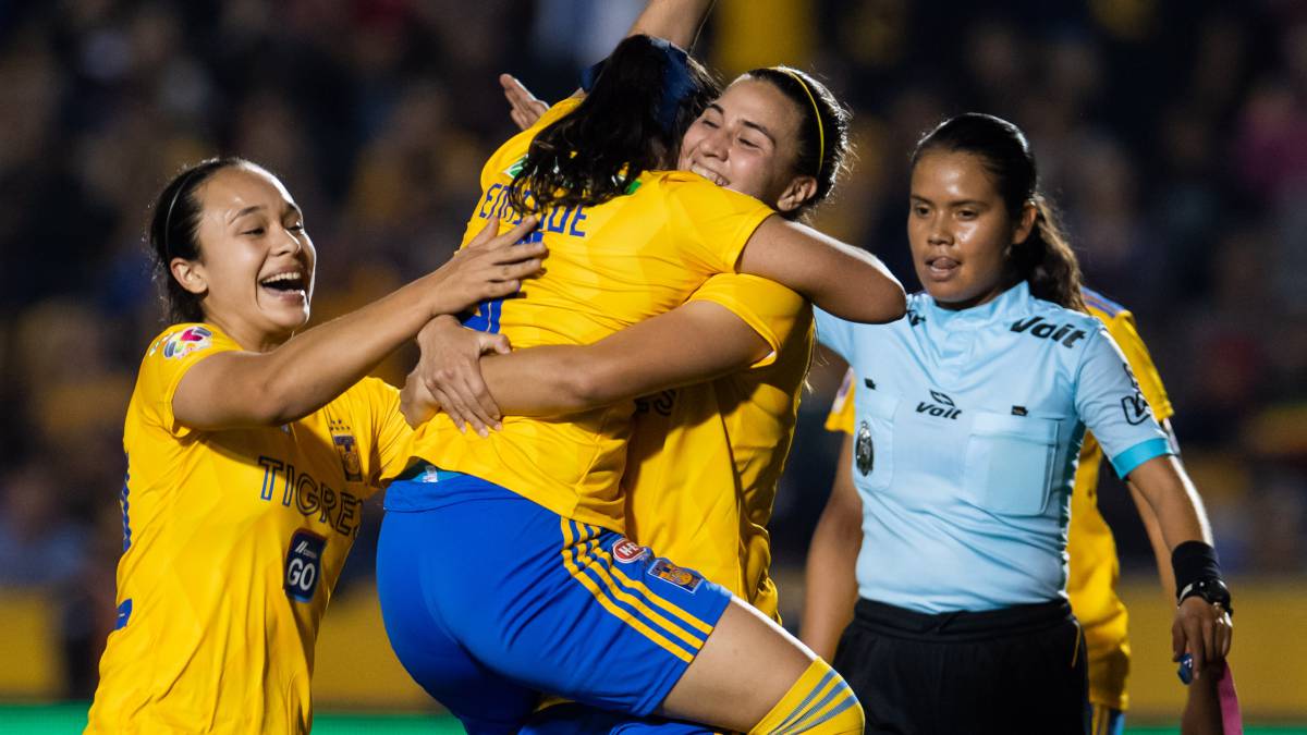 Jugadoras abrazadas festejando anotación