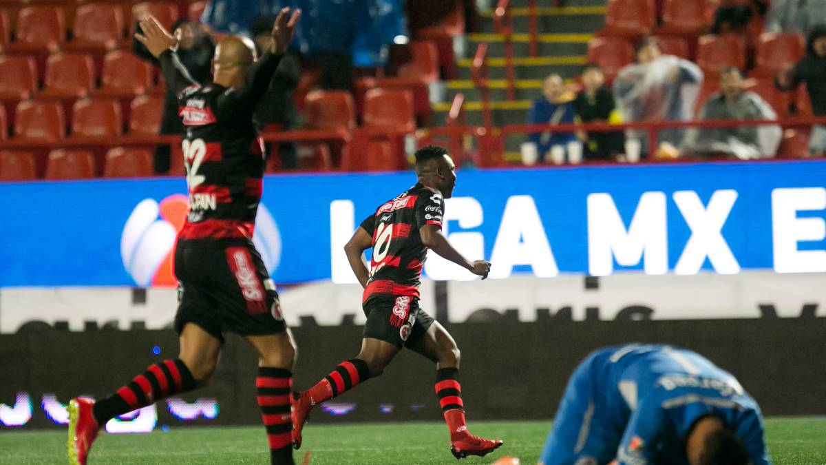 Fabián Castillo y Ariel Nahuelpán festejan gol; Alfredo Talavera, del Toluca, lamenta la anotación