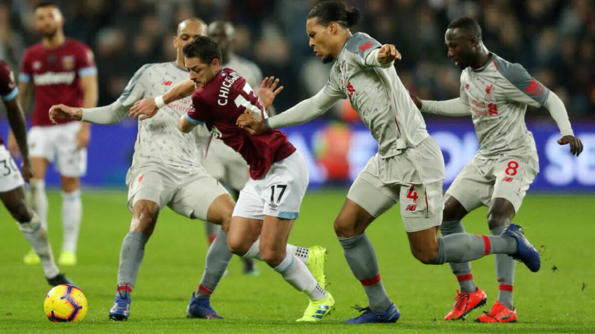 Chicharito conduce el balón entre dos rivales del Liverpool.