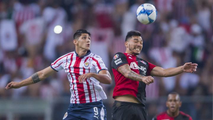 Alan Pulido y Lorenzo Reyes disputan una pelota por alto en el Clásico Tapatío