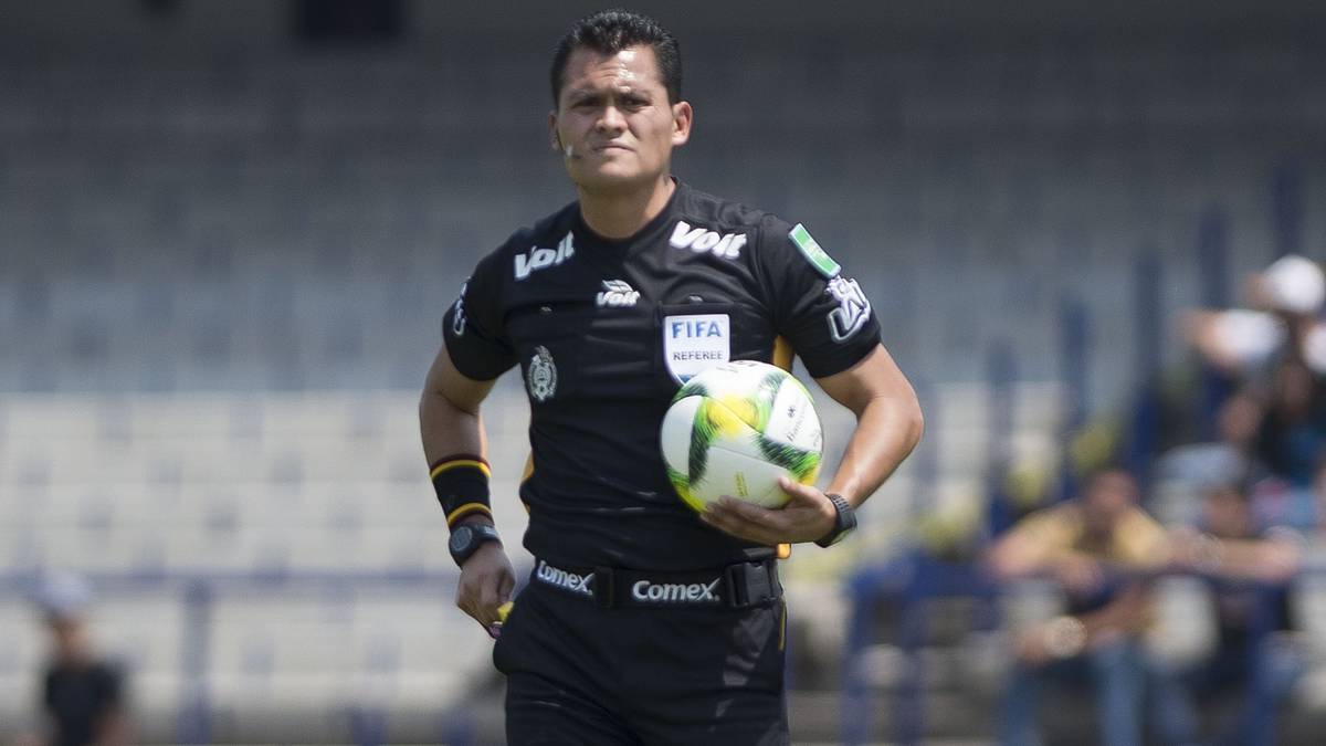 El árbitro central, Jorge Antonio Pérez, camina sobre el césped del Estadio Olímpico Universitario, en el duelo entre Pumas y Monarcas.