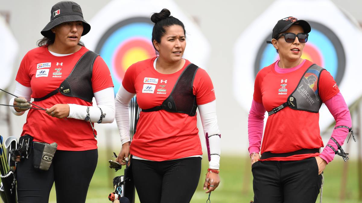 Alejandra Valencia, Mariana Avitia y Aída Roman, caminan en un campo de tiro con arco.