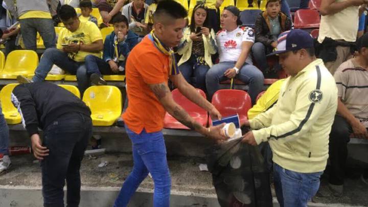 Aficionados del América recogen basura en el Estadio Azteca.