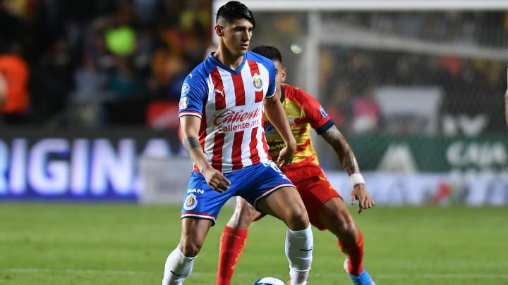 Alan Pulido cubre la pelota ante el asedio de un jugador de Monarcas.