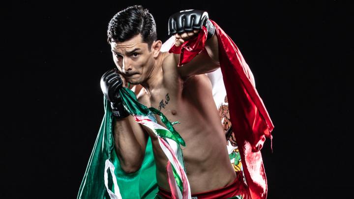 Alejandro Flores en una sesión fotográfica portando una bandera de México.