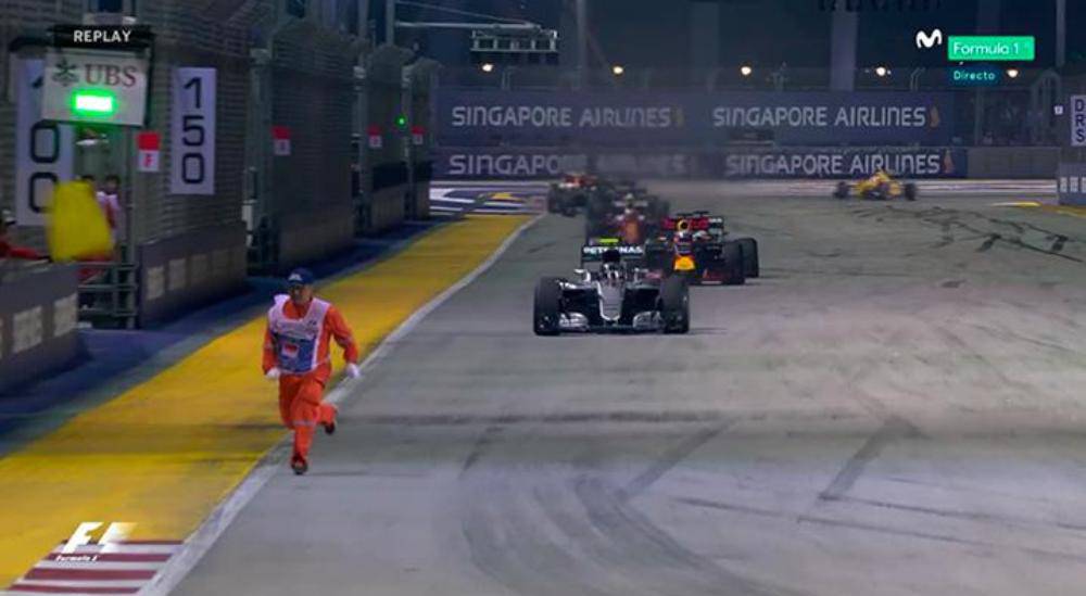 Un comisario esquiva a los coches de F1 en Singapur
