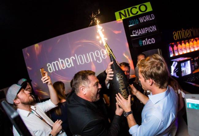 Rosberg agasajado con una botella de champán.