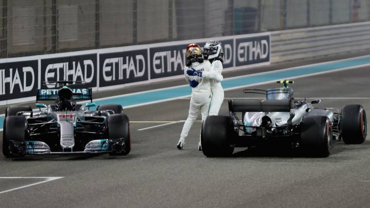 Hamilton y Bottas abrazándose tras la carrera de Abu Dhabi en medio de sus Mercedes.