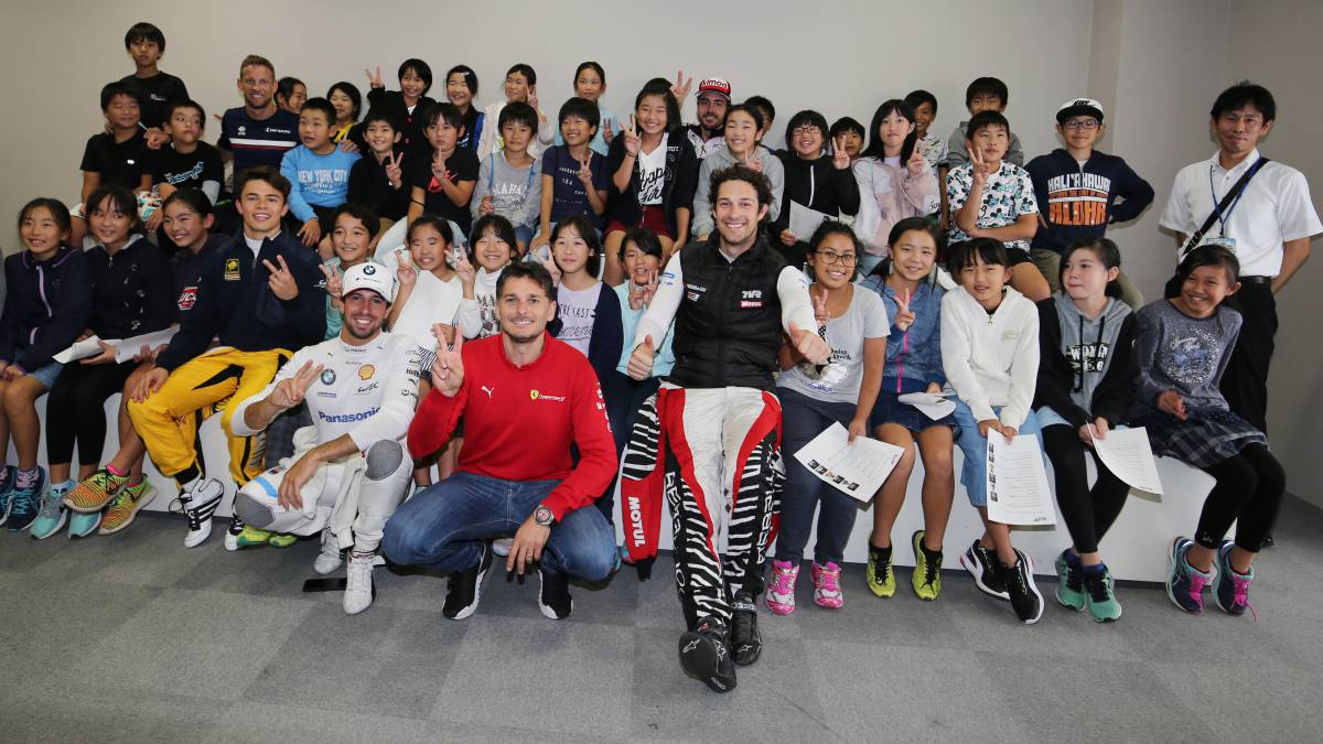 Alonso y el resto de pilotos con los niños de la escuela de primaria.