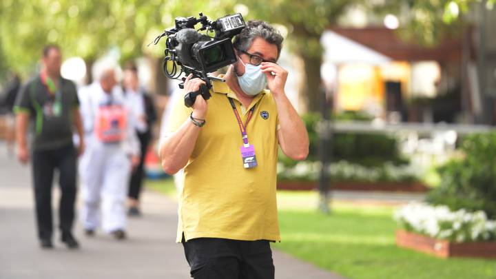 Un cámara con mascarilla en un paddock de F1.