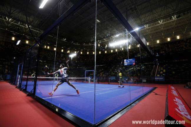 Maxi Sánchez defendiendo una pelota en el fondo de pista en el World Padel Tour.