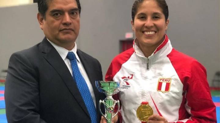 Alexandra Grande, posando con el oro junto a su entrenador Roberto Reyna.