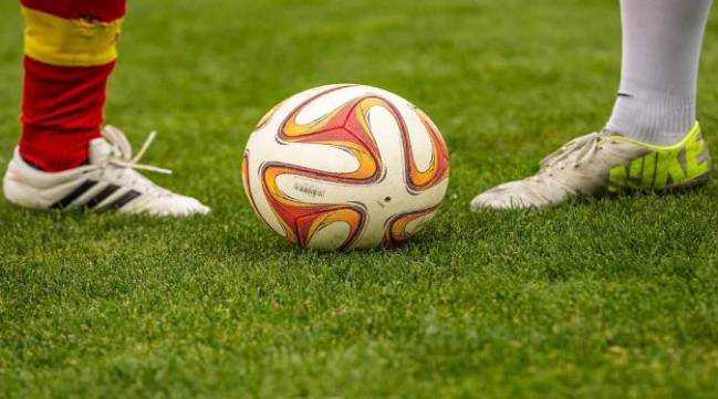 Botas y un balón de fútbol.