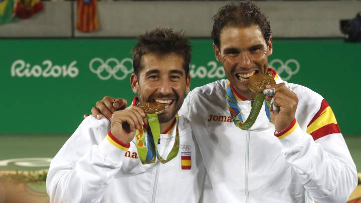 Marc López y Rafa Nadal muerden la medalla de oro lograda en dobles en los Juegos Olímpicos de Río.