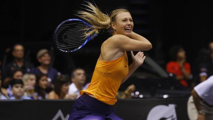 Maria Sharapova responde una bola ante la puertorriqueña Mónica Puig en un partido invitacional en el Coliseo José Miguel Agrelot en San Juan, Puerto Rico.