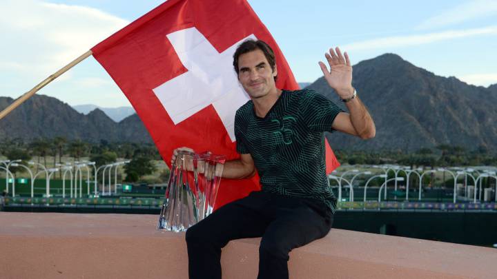 Roger Federer posa con una bandera de Suiza y el trofeo de campeón del BNP Paribas Open de Indian Wells tras ganar en la final a su compatriota Stanislas Wawrinka.