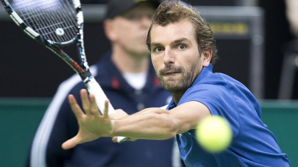 Julien Benneteau devuelve una bola ante Roger Federer durante el torneo de Rotterdam de 2013.