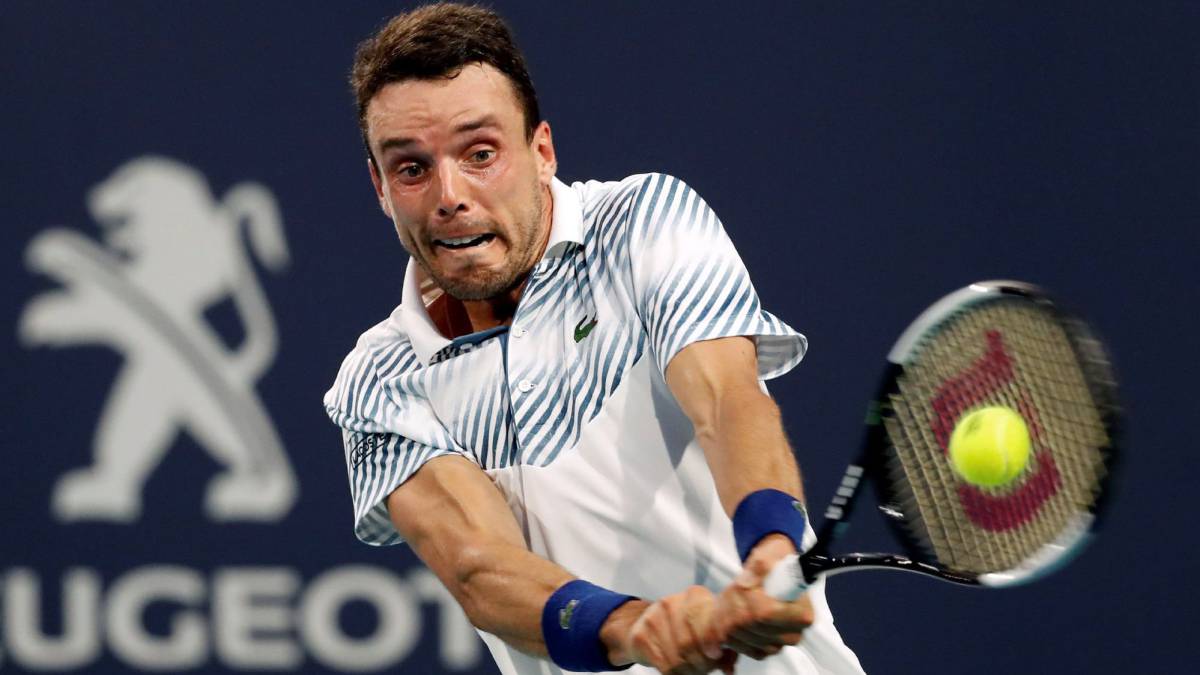 Roberto Bautista devuelve una bola ante Novak Djokovic durante su partido del Abierto de Tenis de Miami.