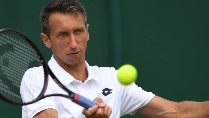 El tenista ucraniano Sergiy Stakhovsky devuelve una bola ante Sam Querrey durante su partido en el torneo de Wimbledon de 2018.
