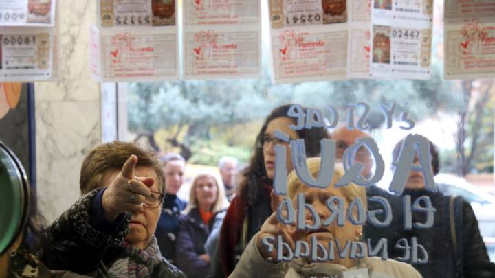 Una mujer señala un décimo de la Lotería en una administración.