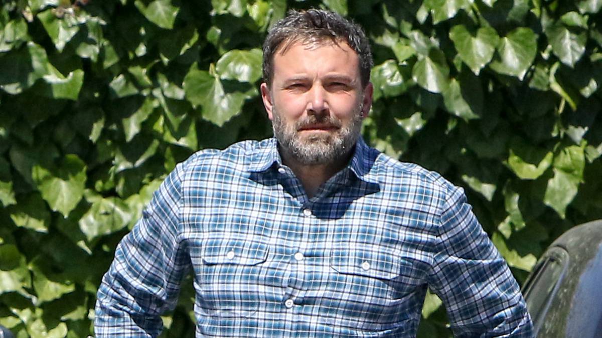 El actor y director Ben Affleck con una camisa de cuadros en unos aparcamientos.