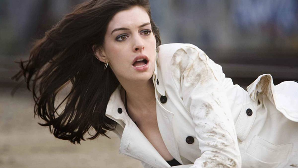 La actriz Anne Hathaway con una gabardina blanca.
